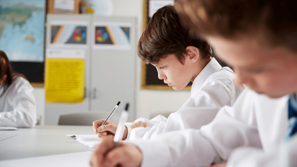 KS3 student writing at table with pen
