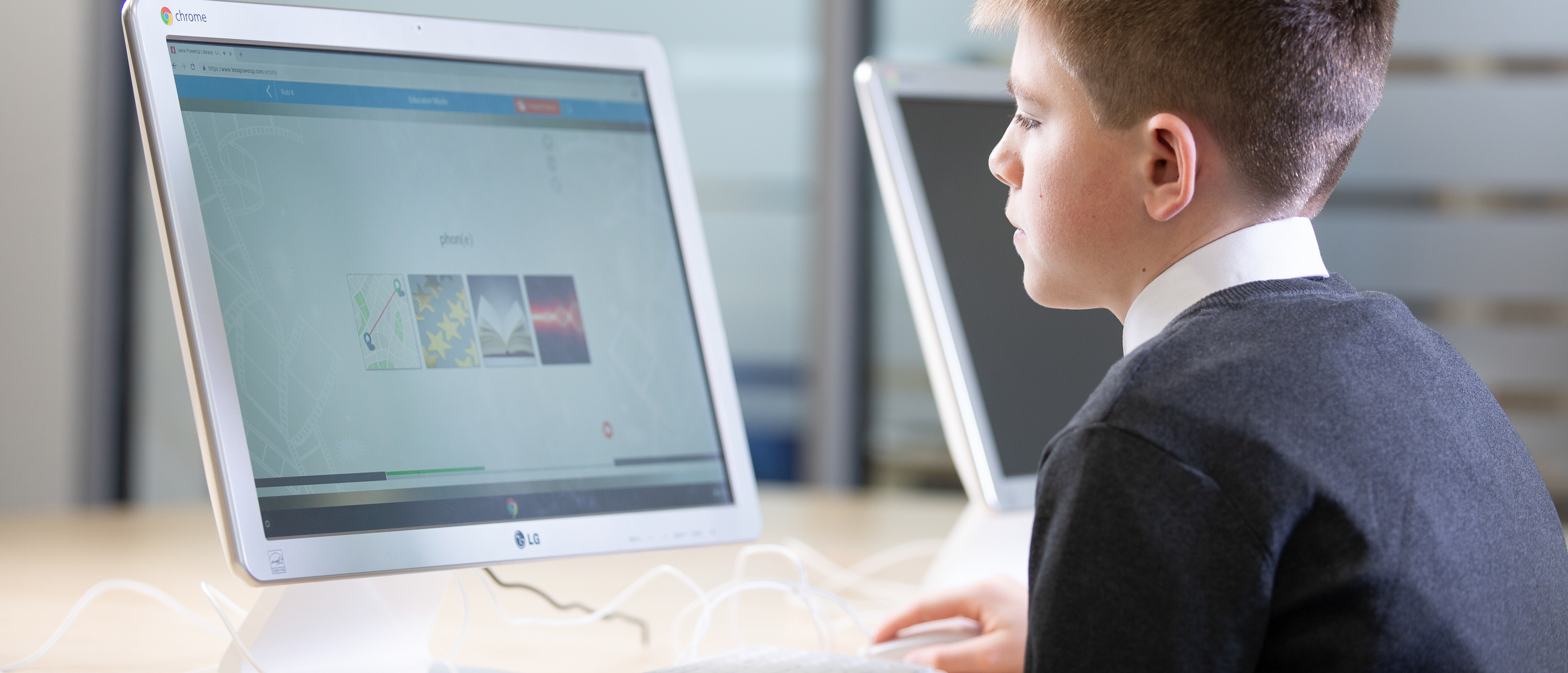 Secondary school-age boy using Lexia literacy software for schools on a desktop computer