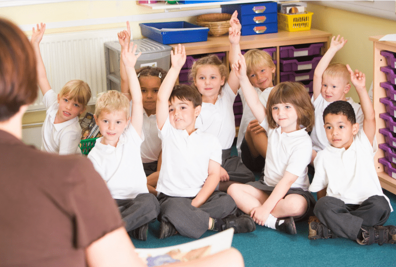 KS1 pupils with ALL their hands raised
